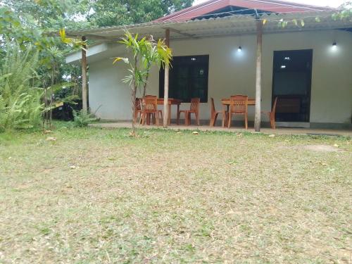 a house with a patio with a table and chairs at Birds rock villa Sinharaja in Deniyaya