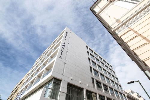 a tall white building with the sky in the background at Amalia Hotel Athens in Athens