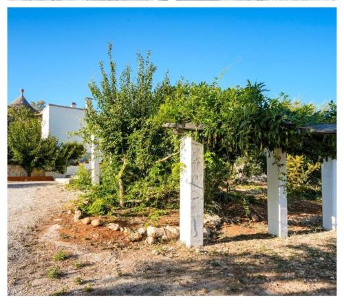 a garden with a fence with trees on it at Casa vacanze La Campanella in Putignano
