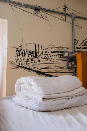 a stack of white pillows on a bed in a room at The Full Moon Backpackers in Bristol