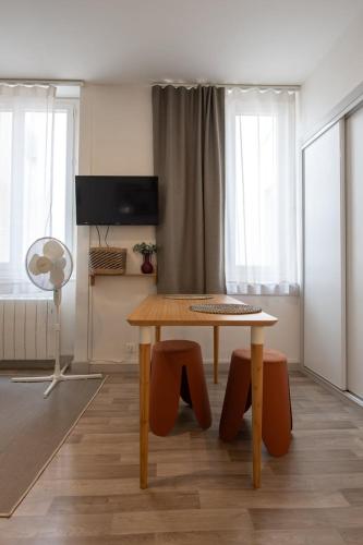 un salon avec une table et deux chaises dans l'établissement Le Cocon de Cordeliers, à Lyon