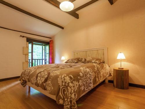 NantheuilにあるSpacious farmhouse with private heated pool in a rustic gardenのベッドルーム1室(ベッド1台、ランプ2つ、窓付)