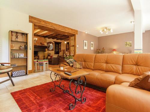 un salon avec un canapé et une table dans l'établissement Spacious farmhouse with private heated pool in a rustic garden, à Nantheuil