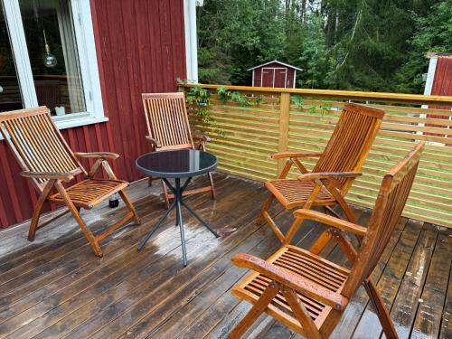 three chairs and a table on a deck at Torp ved Mårbacka (Helt hus til leie) Östra Ämtervik/ Sunne in Östra Ämtervik