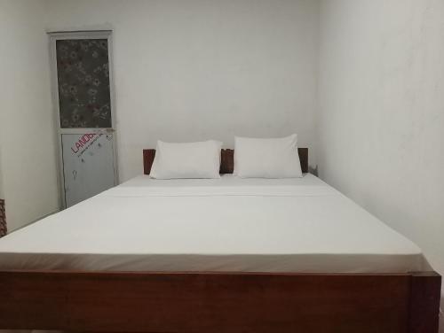 a bedroom with a large bed with white sheets at Birds rock villa Sinharaja in Deniyaya