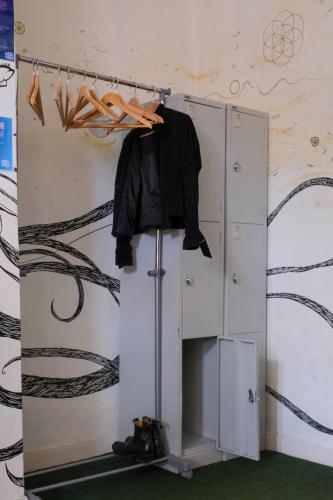 a wardrobe with a black shirt hanging on a wall at The Full Moon Backpackers in Bristol