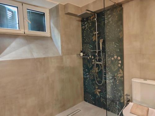 a bathroom with a shower with a glass door at CORFU TENNIS Studios in Agios Rokkos