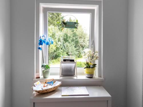 a window with vases and a table in a room at Gailtaler apartment at an excursion location in Kötschach