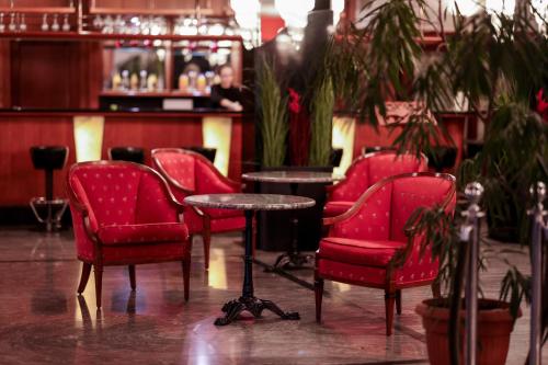 a group of red chairs and a table in a bar at Park Hotel Diament Bielsko-Biała in Bielsko-Biala