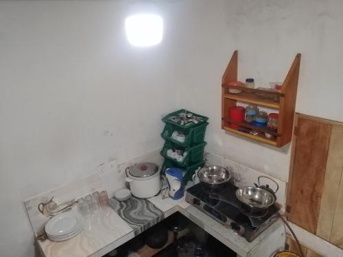 a small kitchen with a stove and a counter top at Birds rock villa Sinharaja in Deniyaya