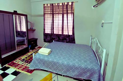 a bedroom with a bed and a window at Yatie House in Melaka