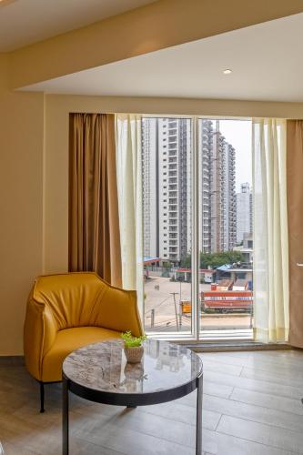 a living room with a yellow couch and a glass table at Saltstayz Premier - Manesar & Sector 86 in Gurgaon