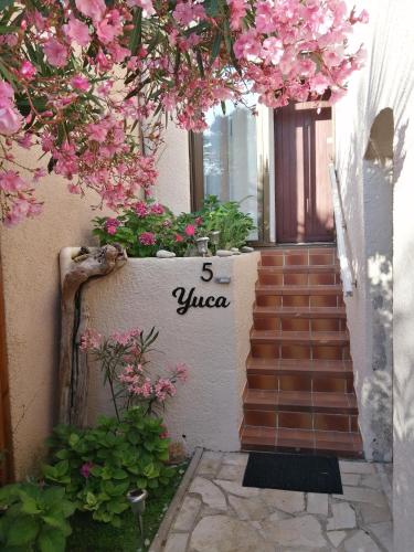 a staircase with pink flowers on the side of a building at Yuca in Vallauris