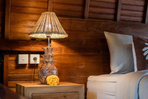 una lampada seduta su un tavolo accanto a un letto di Yama Villa & SPA Ubud a Payangan