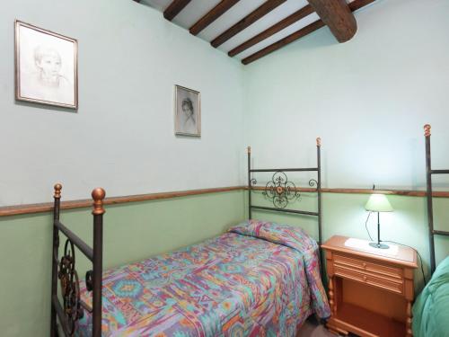 a bedroom with a bed and a table with a lamp at Farmhouse in Apecchio with Swimming Pool, Terrace, Garden in Apecchio