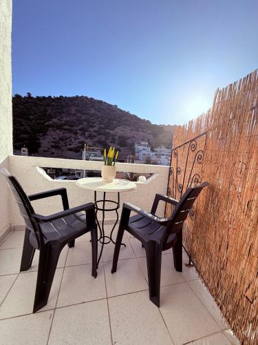 a patio with two chairs and a table on a balcony at Argiro's apartment at Agia Galini in Agia Galini
