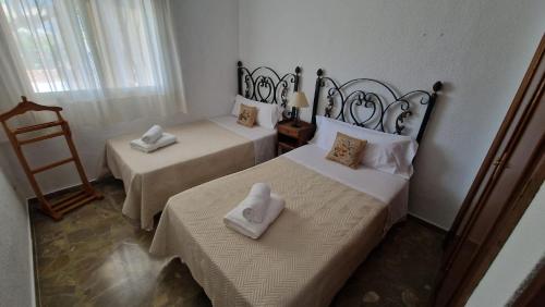 a bedroom with two beds with towels on them at La Barrosa - Chalet La Morenita in Chiclana de la Frontera