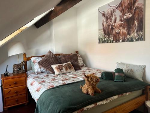 un cane seduto su un letto in una camera da letto di Historic 1600’s The Grocer’s Cottage a Heysham