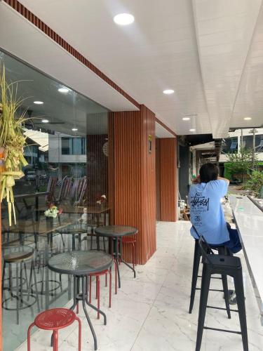 a man sitting on a stool in a restaurant at Hotel Sanrina Kuta Bali in Kuta