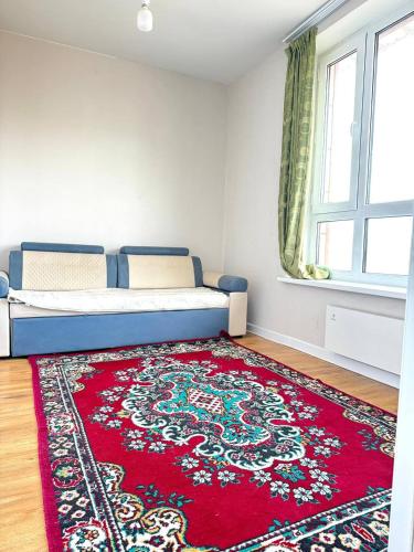 a bedroom with a bed and a red rug at Cozy year-round cottage near UB with additional pick-up service from the Airport in Dzuunmod