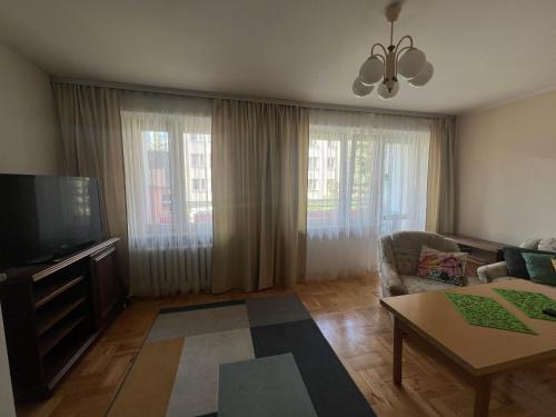 a living room with a couch and a tv at Przytulne mieszkanie m3 Gorlice in Gorlice