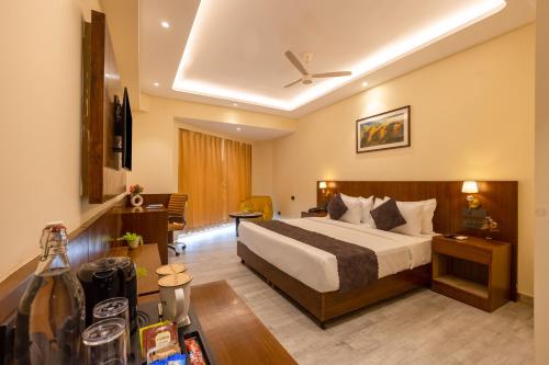 a hotel room with a bed and a desk at Saltstayz Premier - Manesar & Sector 86 in Gurgaon