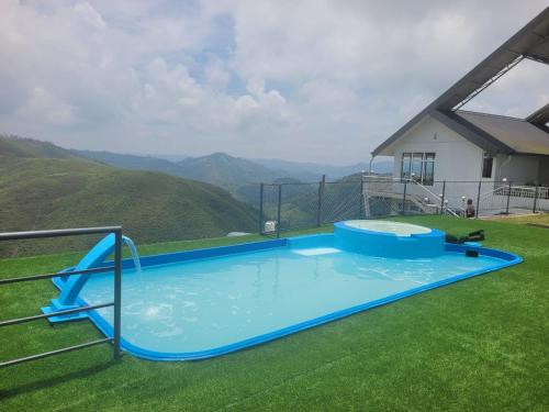 a large blue swimming pool with a view of a mountain at Castra villas - Pool Villa in Parunthumpara in Vandiperiyār