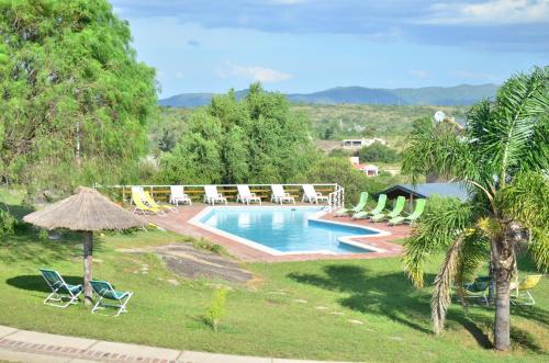 a pool with chairs and umbrellas in a resort at Complejo Las Hoyas in Villa Carlos Paz
