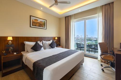 a hotel room with a bed and a balcony at Saltstayz Premier - Manesar & Sector 86 in Gurgaon