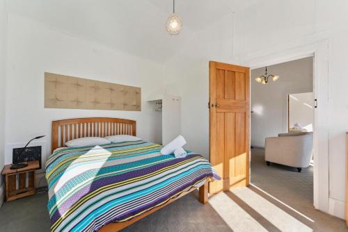 ein Schlafzimmer mit einem Bett und ein Badezimmer mit einem Waschbecken in der Unterkunft Ruapehu Cottage - Ohakune Holiday Home in Ohakune