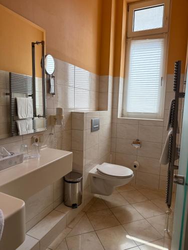 a bathroom with a toilet and a sink at Hotel Union Salzwedel in Salzwedel