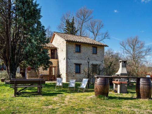 a table and chairs in front of a house at Modern Holiday Home in Pietrafitta Umbria with Garden in Pietrafitta