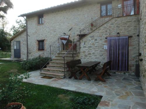 a stone house with a picnic table and stairs at Modern Holiday Home in Pietrafitta Umbria with Garden in Pietrafitta