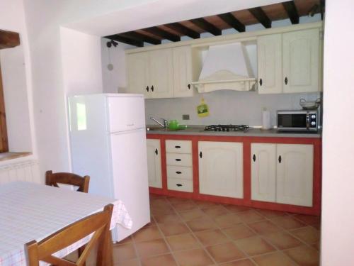 a kitchen with white cabinets and a white refrigerator at Modern Holiday Home in Pietrafitta Umbria with Garden in Pietrafitta