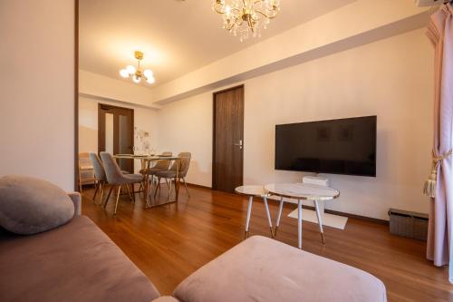 a living room with a couch and a flat screen tv at Ushamy's KOKURA STAY No 03 in Kitakyushu