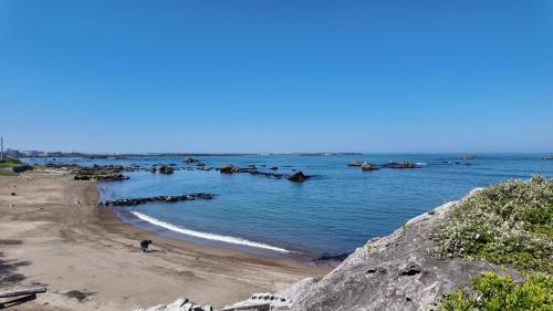 a beach with a group of rocks in the water at SunVILLA EASTEND in Choshi