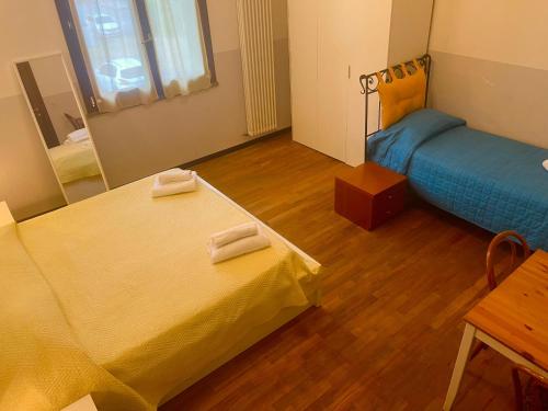 a room with two beds and a table and a mirror at Il Cielo di Lucio in Pisa