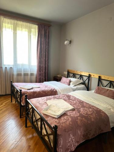a hotel room with two beds and a window at Yeghevnut Hotel in Goris