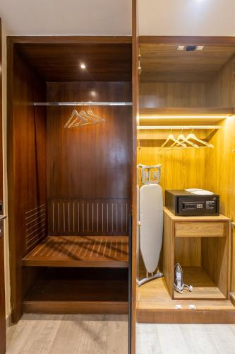 a walk in closet with wooden walls and a refrigerator at Saltstayz Premier - Manesar & Sector 86 in Gurgaon