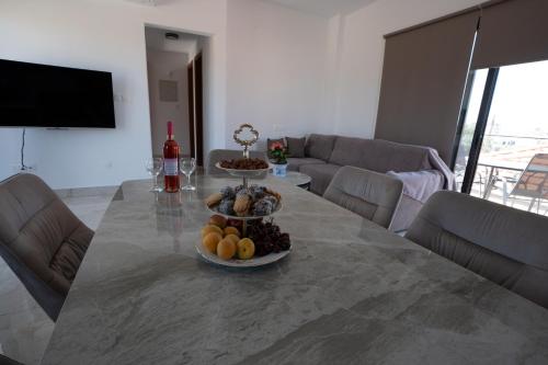 a table with a bowl of fruit on it in a living room at ARMA CIELO III, 2-bed Cosy Flat in Paphos City