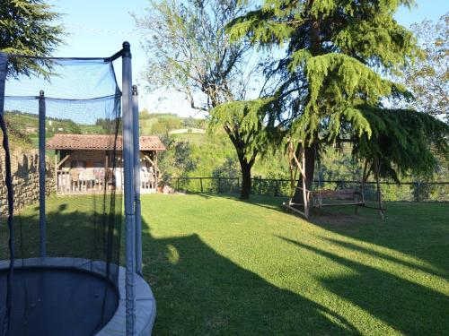 a batting cage in a yard with a tree at Apartment in quiet and green environment with swimming pool in Modigliana