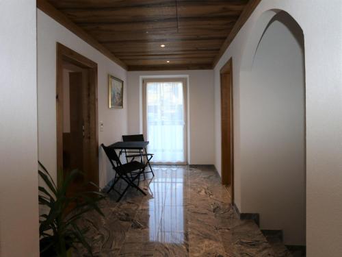 a hallway with a table and chair in a house at High-quality holiday apartment in Oberkrimml near waterfalls in Krimml