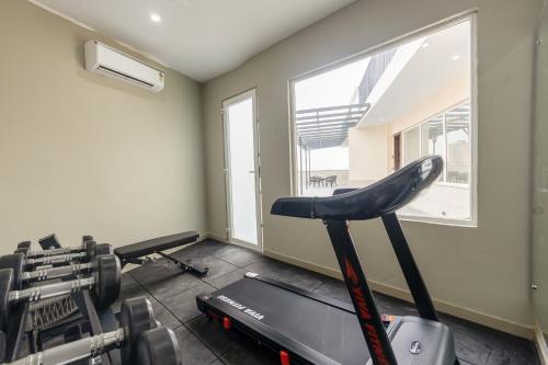 a room with a gym with a treadmill and a window at Saltstayz Premier - Manesar & Sector 86 in Gurgaon