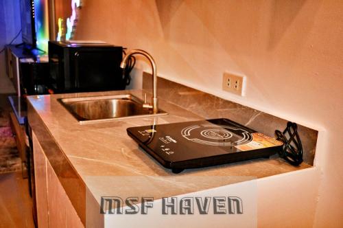 a kitchen counter with a stove and a sink at MSF Haven in Manila