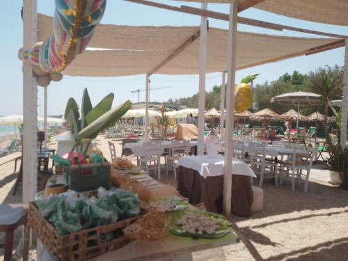 a group of tables and chairs with tables and umbrellas at residenza il capitano in Roseto degli Abruzzi