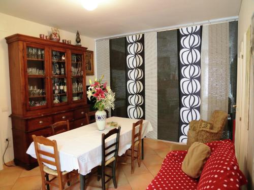 a dining room with a table and a couch at Apartment in quiet and green environment with swimming pool in Modigliana