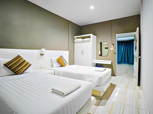 a hotel room with two beds and a mirror at Paragon Hometel in Surat Thani