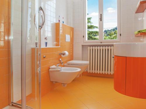 an orange bathroom with a toilet and a shower at Apartment in quiet and green environment with swimming pool in Modigliana