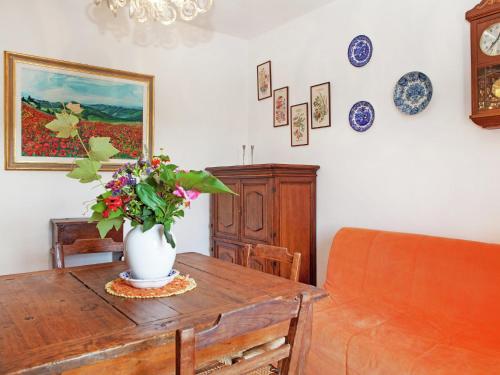 a room with a table with a vase of flowers on it at Apartment in quiet and green environment with swimming pool in Modigliana