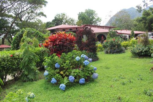a garden with colorful flowers in the grass at Hotel Valle Verde in Valle de Anton